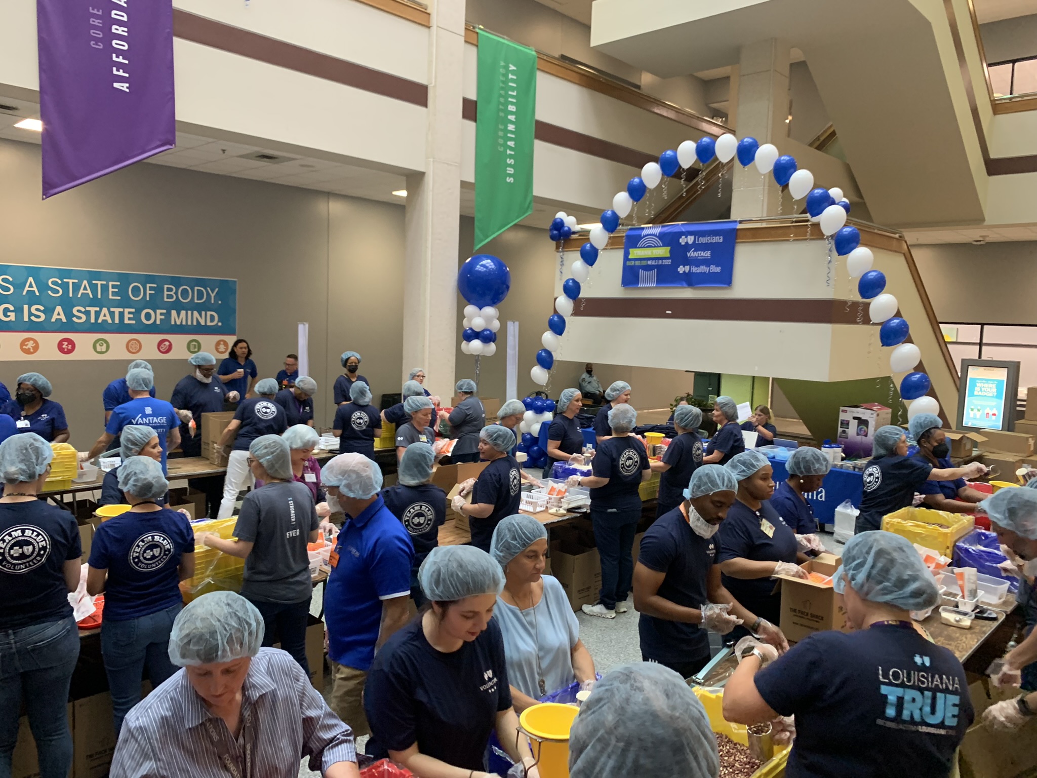 Employee-volunteers of Blue Cross and Blue Shield of gather to pack meals in the atrium of the company’s corporate headquarters in Baton Rouge. Last year, Blue Cross employee volunteered more than 55,000 hours, leading them to be named nationwide volunteer champions by Points of Light Foundation.